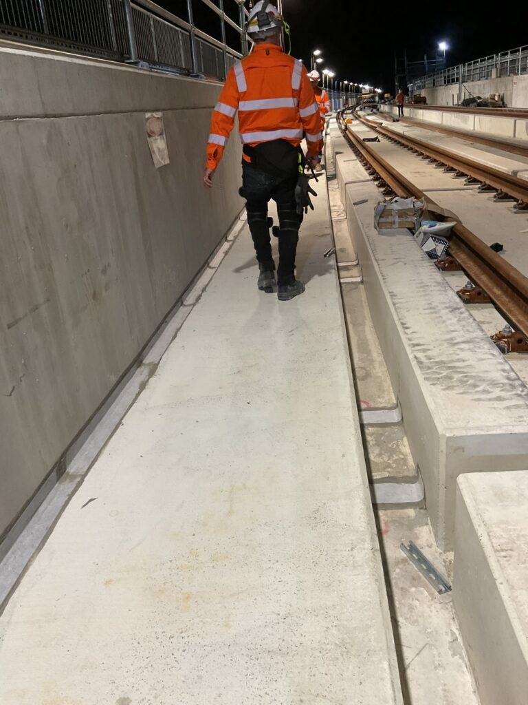 Waterseal crew member inspecting a waterproofed viaduct joint during a night shift